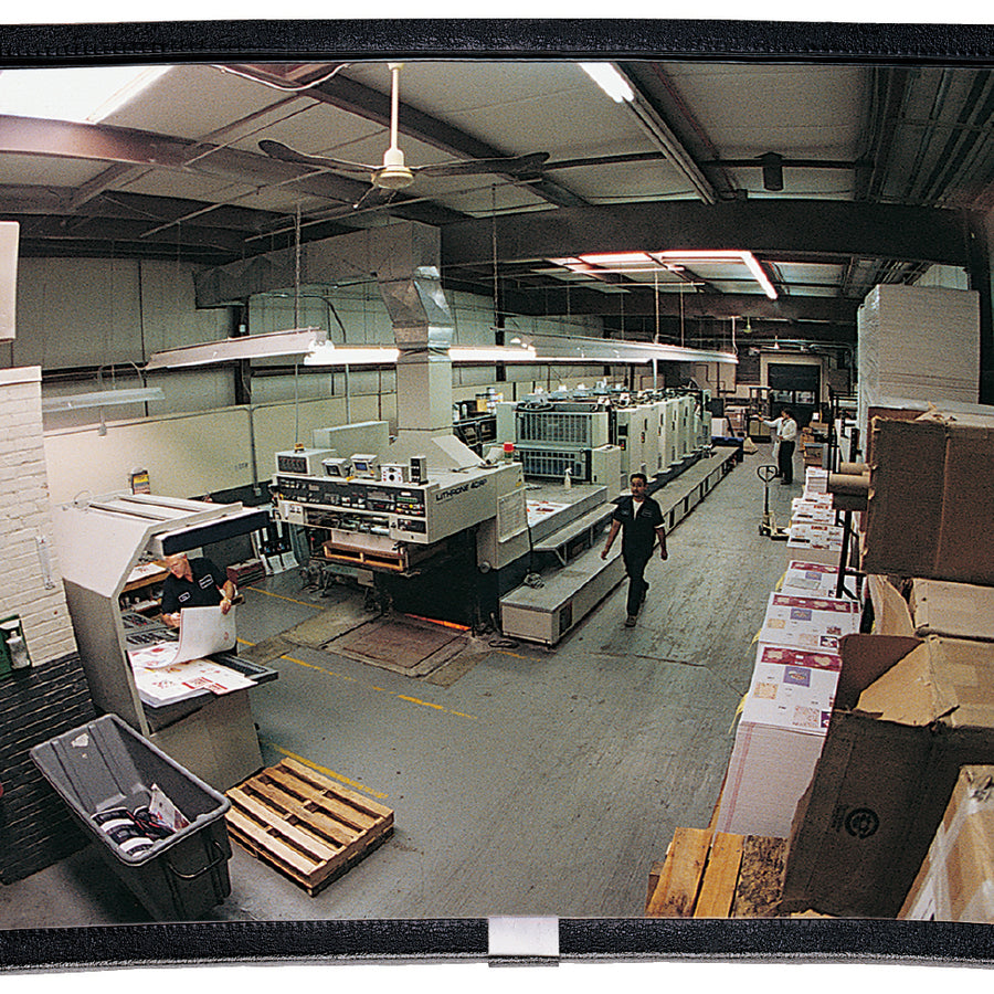Large rectangular mirror reflecting a warehouse interior with workers and equipment.