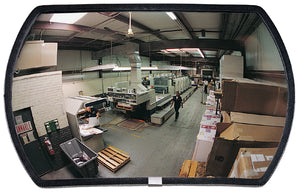 Large rectangular mirror reflecting a warehouse interior with workers and equipment.